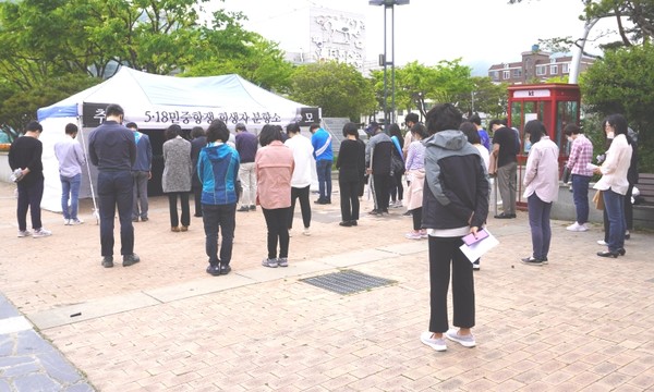 해남교육지원청 직원들과 교사들이 광주항쟁 40주년을 맞아 군민광장 앞에 차려진 분향소에서 묵념을 하고 있다. 