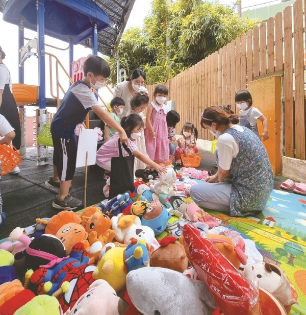 동심어린이집 유아들이 나눔장터에서 물건을 구매하고 있다.