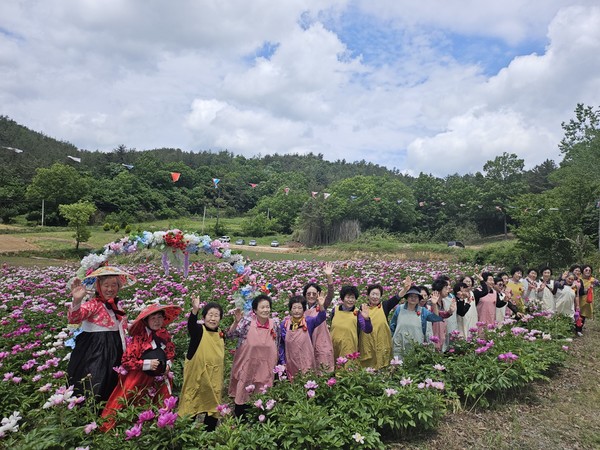 작약축제에 놀러온 화산면 꽃메합창단 할머니들이 즉석 공연을 펼치기 전 손을 흔들고 있다. 