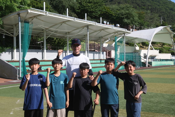 강철민 감독이 야구 꿈나무들과 포즈를 취하고 있다.