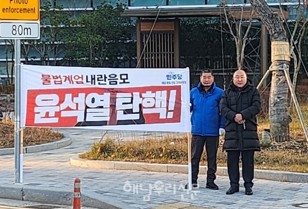 해남군의회 이성옥 의장과 한종천 민주당 당직자가 해남군청 민원실 사거리에 피켓시위를 하고 있다.