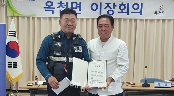 송우종 옥천면이장단장이 김광중 경위에게 감사장을 전달하고 있다.