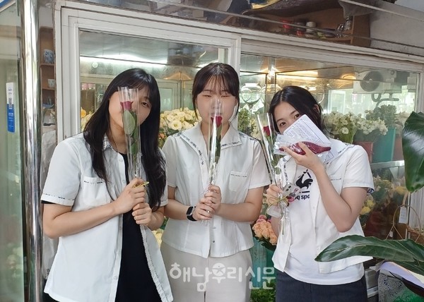               생애 첫 투표를 마친 청소년들이 조명옥 꽃방에서 축하 장미꽃을 받았다.