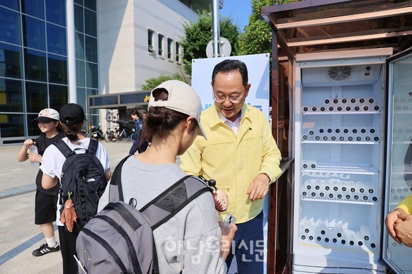 명현관 군수가 군민광장에 설치된 나눔 냉장고에서 생수를 나누고 있다.