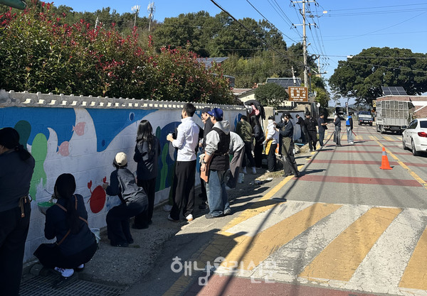 해남공업고등학교 학생들이 마산 안정마을에서 벽화를 그리고 있다.